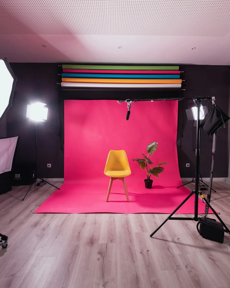 Plató con fondo de color liso, silla y equipo de iluminación preparado para una sesión de retrato